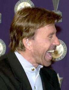 Chuck Norris being shown a Bambi figurine at an Air Force awards show.